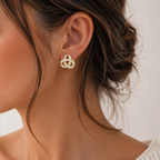 Anna, puce d'oreille dorée en nœud entrelacé pavé de zircons, portée par un mannequin au chignon bas