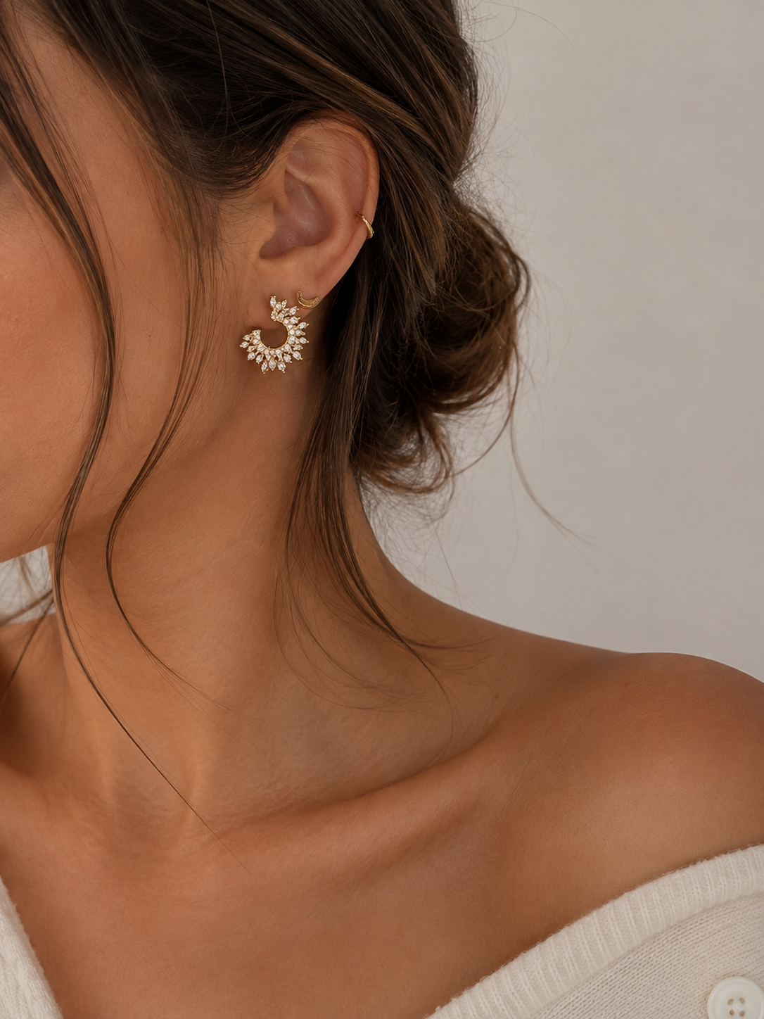 Arïna, boucles d'oreilles dorées demi-soleil serties de zircons marquise, portées par un mannequin