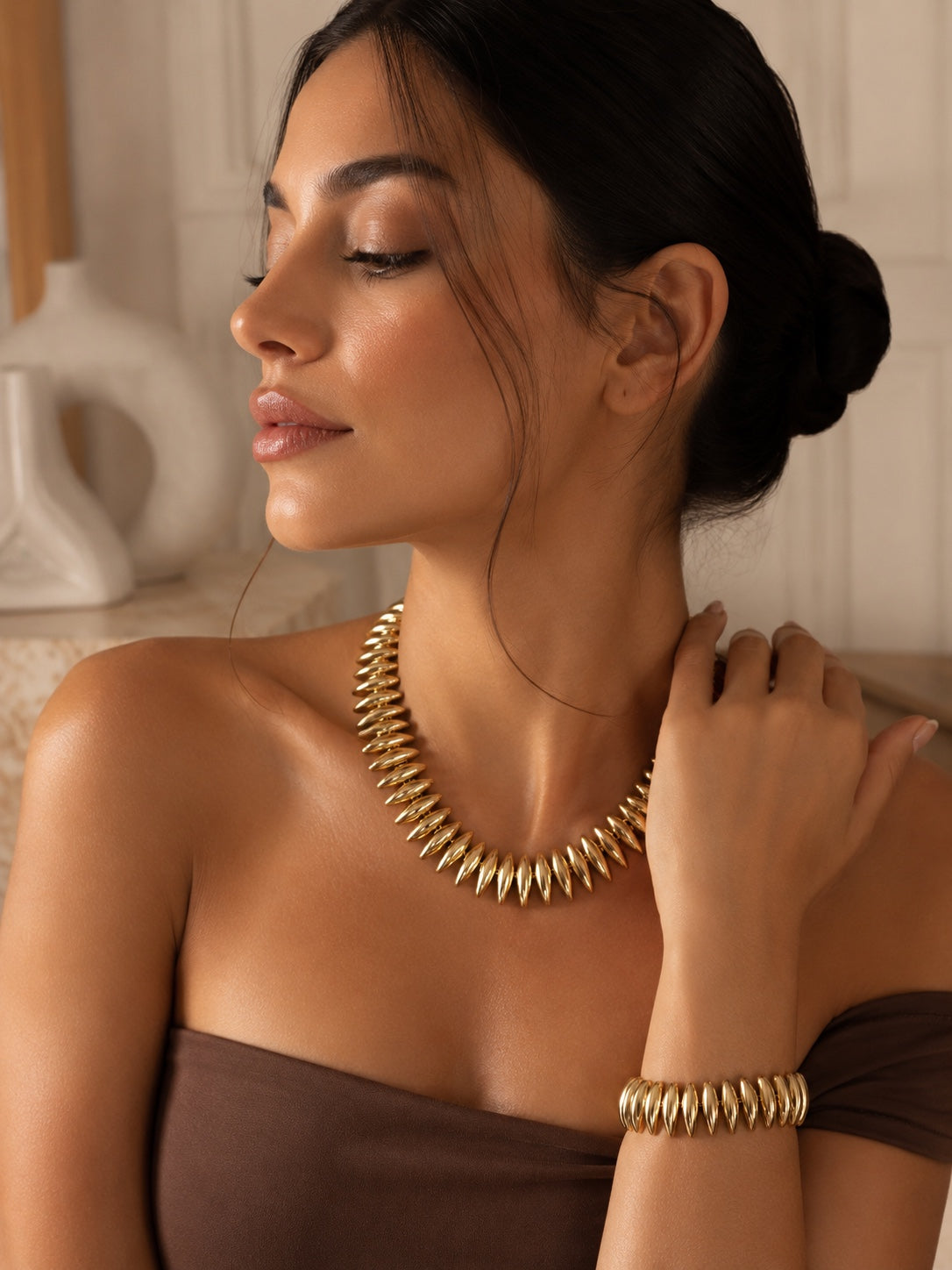 Alicia, collier et bracelet dorés à grains bombés, portés par un mannequin