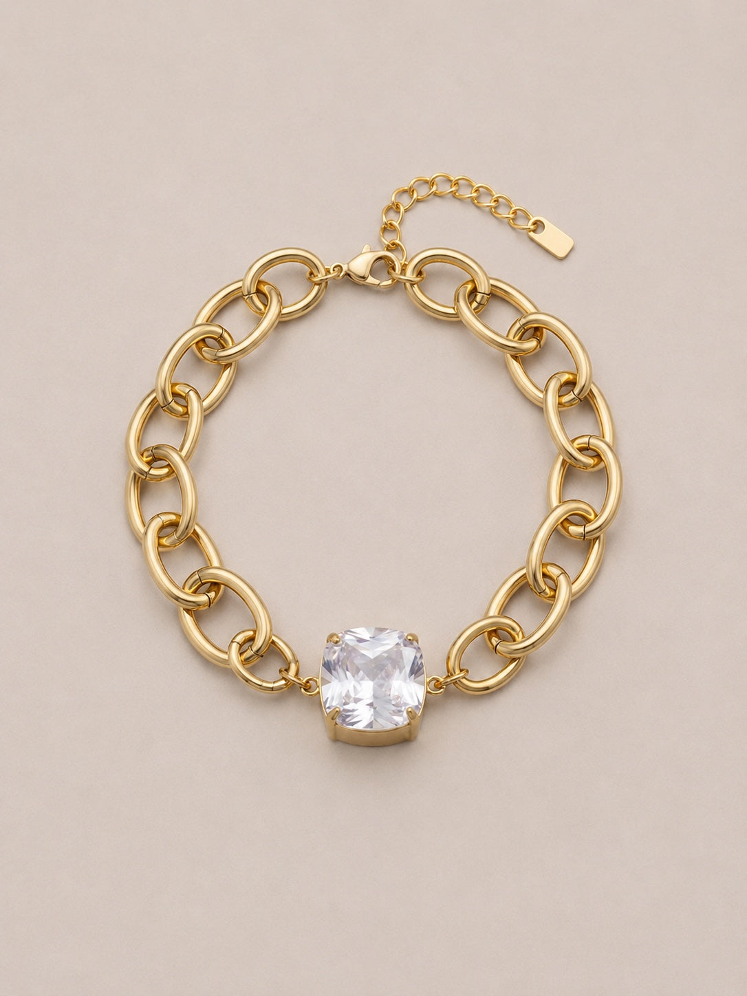 Alix, bracelet doré à gros maillons et pierre blanche taille coussin, packshot sur fond beige