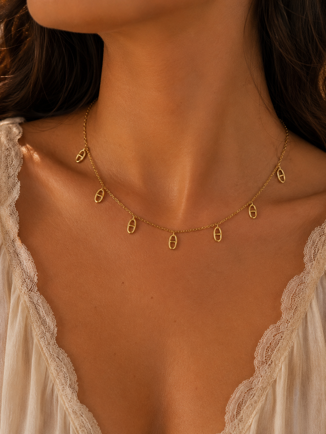 Arielle, collier doré à breloques maillon marine, porté par un mannequin